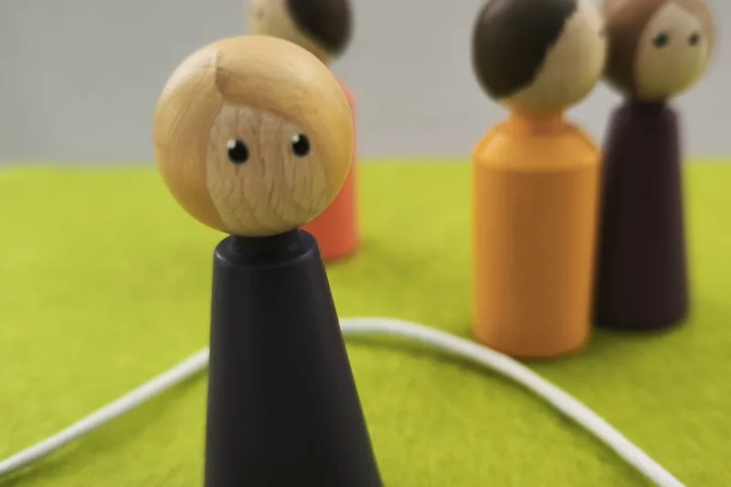 Holzfiguren auf grüner Fläche